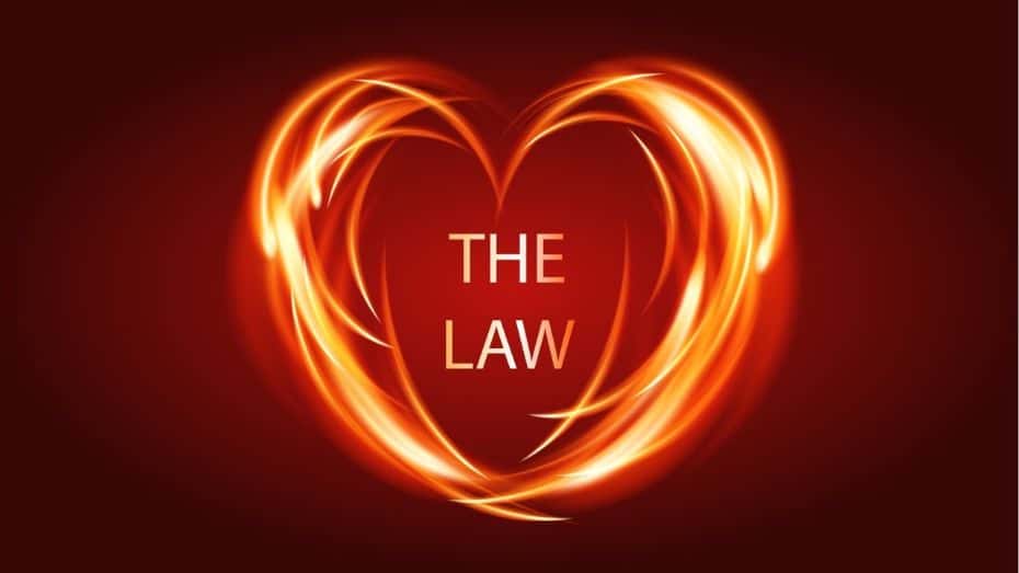 A vibrant, glowing heart shape formed by fiery orange and yellow light streaks against a dark red background, with the words "THE LAW" written in white text in the center of the heart.