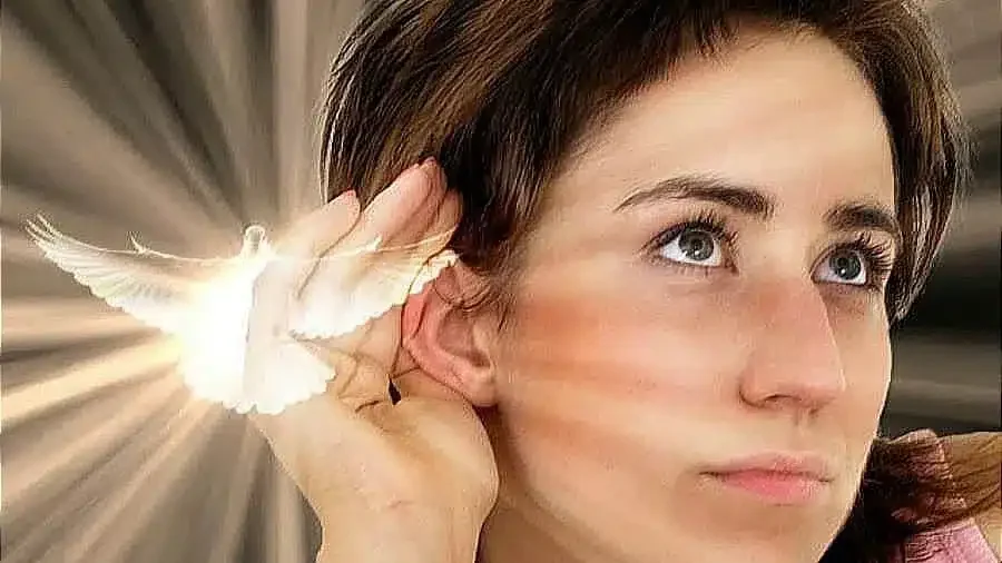 A bright dove appears beside a woman's ear, urging her to listen to the Holy Spirit for guidance. I love you, Jesus.