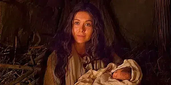 A serene portrayal of a woman holding Jesus wrapped in swaddling clothes.