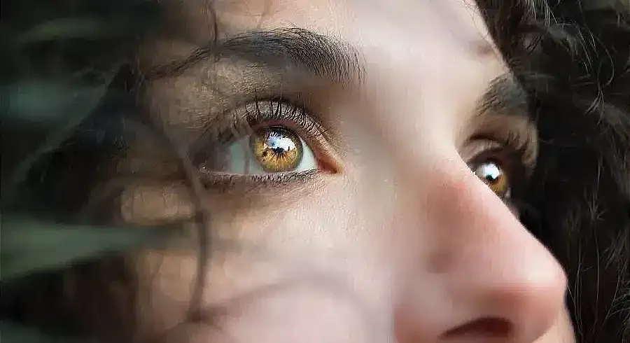 Close-up of a person's eyes looking upwards, symbolizing contemplation and overcoming self-doubt and fear of failure.