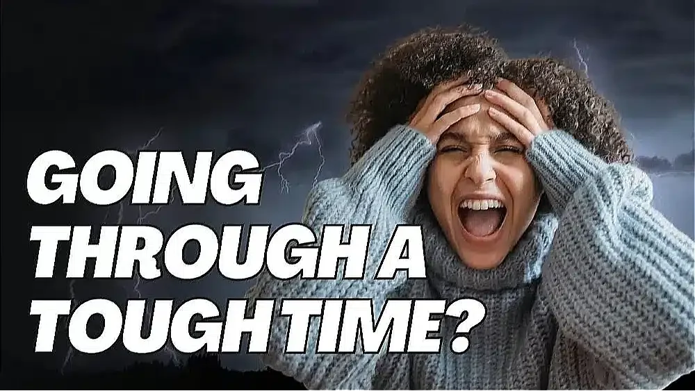 A distressed woman with her hands on her head, wearing a thick sweater, and a stormy background; text reads "Going through a tough time?"